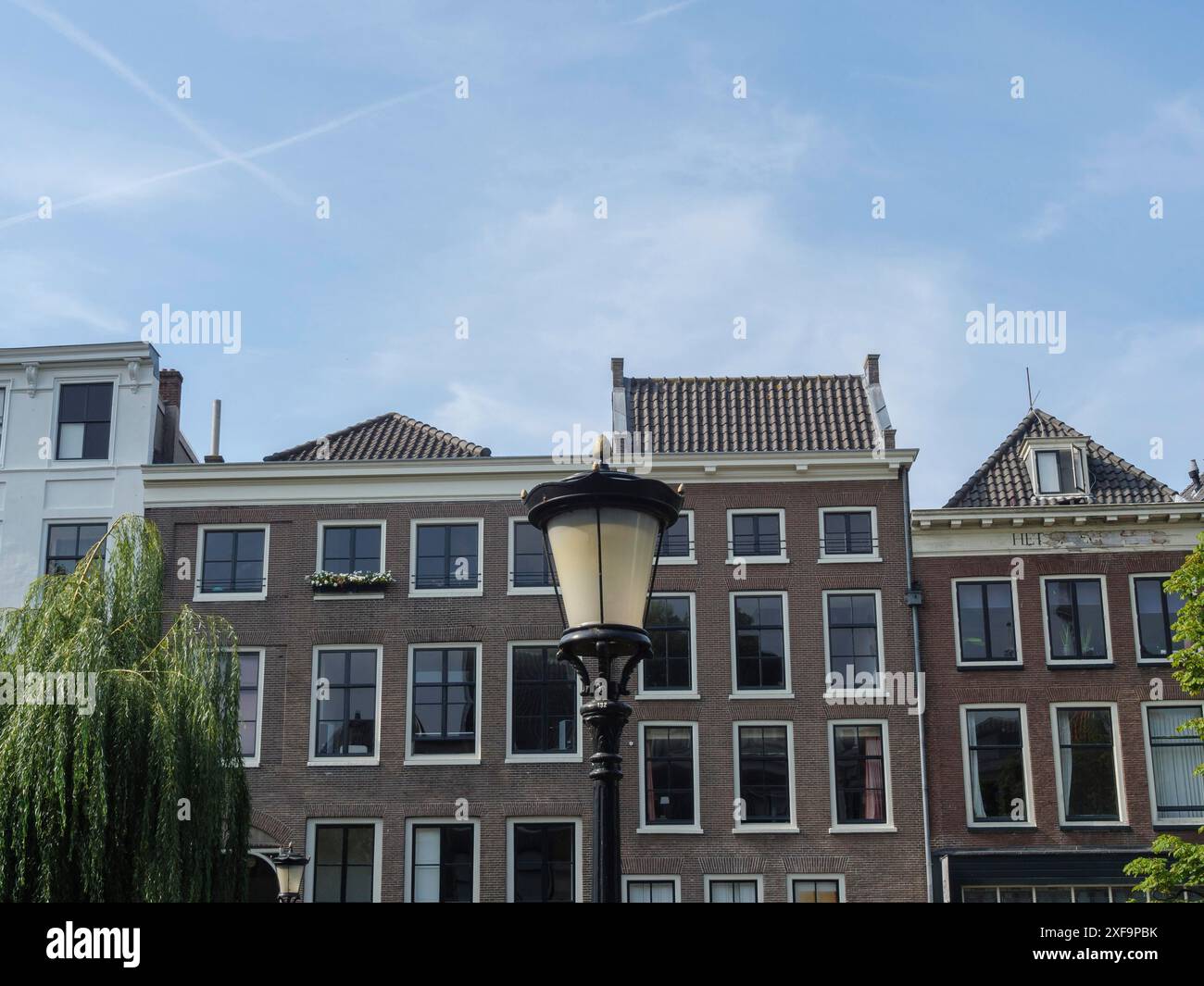 Historisches Gebäude mit zentralem Leuchtenpfosten unter blauem Himmel, utrecht, niederlande Stockfoto