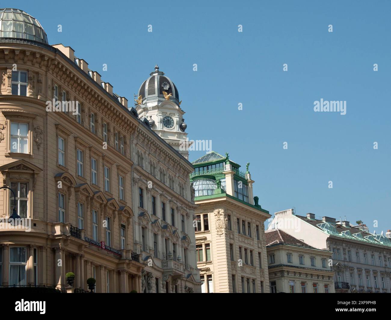 Straßenszene mit historischen Gebäuden und überkreuztem Turm unter klarem blauen Himmel, Wien, Österreich Stockfoto