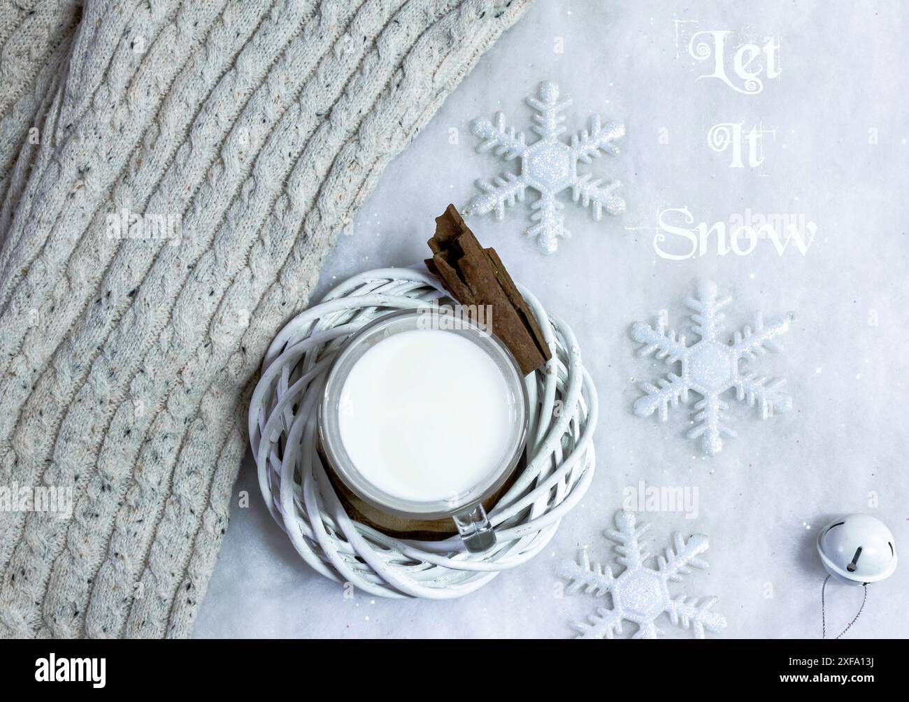 Warme Milch und Zimt auf falschem Schnee Hintergrund mit Text Stockfoto