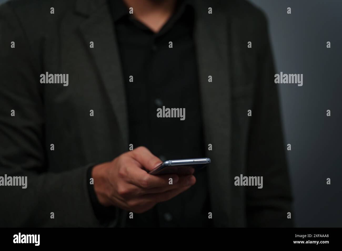 Hand eines Geschäftsmannes im Anzug mit Smartphone Stockfoto