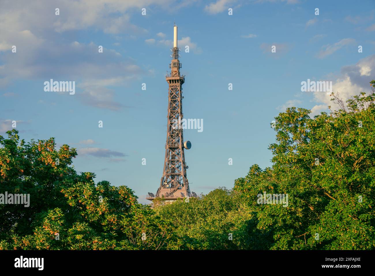 Der berühmte Metallic Tower von Lyon, Frankreich, erhebt sich im Frühling über den grünen Bäumen vor dem blauen Himmel bei Sonnenuntergang Stockfoto