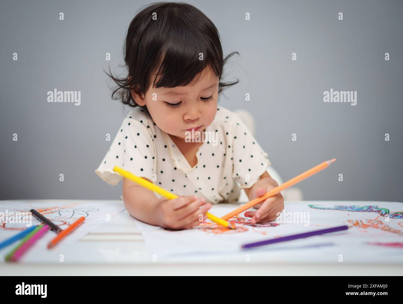 Kleinkind spielt und trainiert mit dem Farbstift auf dem Tisch Stockfoto