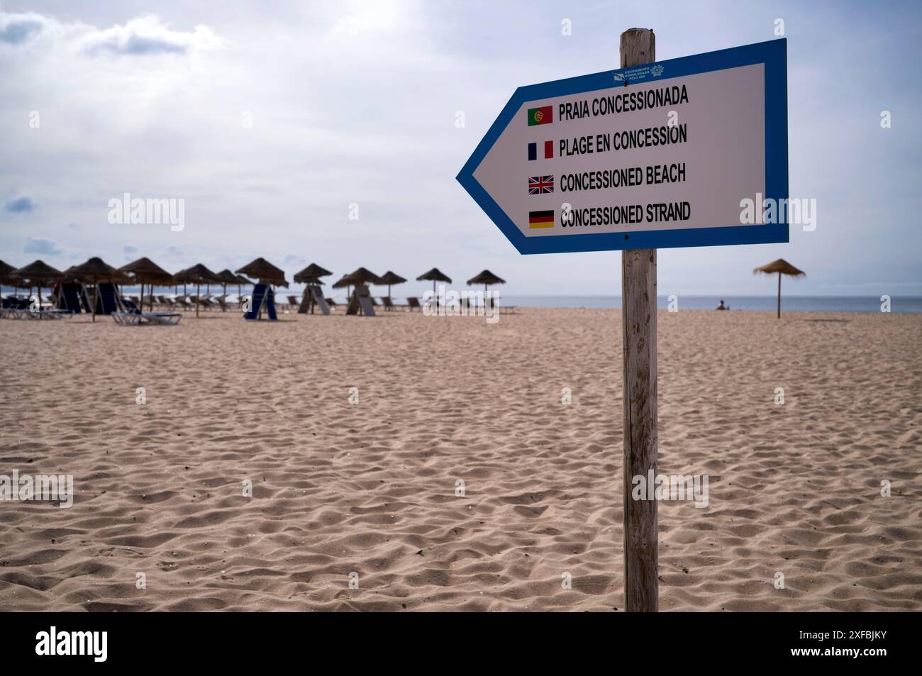 Schild Sandstrand, bewacht, Konzessionsstrand, mehrsprachig, Portugiesisch, Französisch, Englisch, Deutsch, Liegestühle, Sonnenschirme, Meia Praia Beach, Lagos Stockfoto