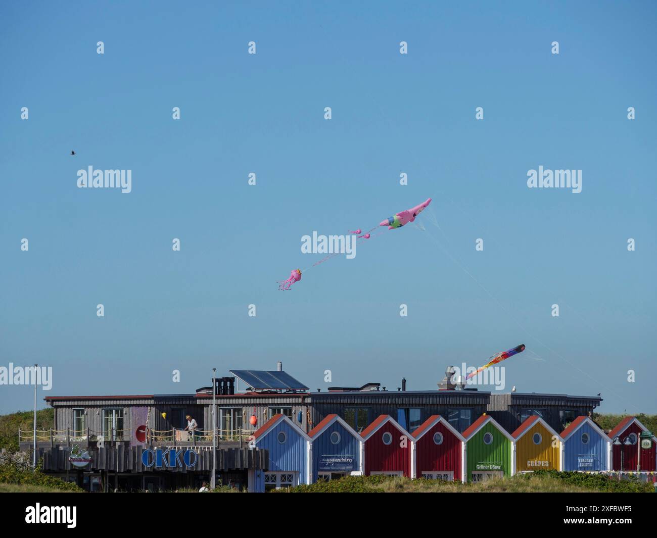 Bunt bemalte Gebäude mit Drachen, die über dem hellblauen Himmel fliegen Stockfoto