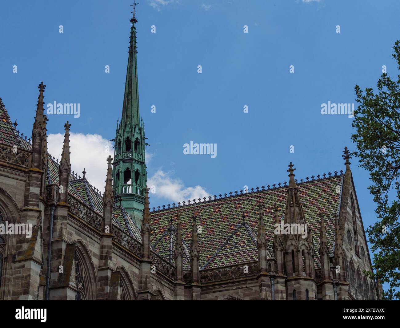 Kirchendach mit grünem Turm vor teilweise bewölktem blauen Himmel, speyer, deutschland Stockfoto