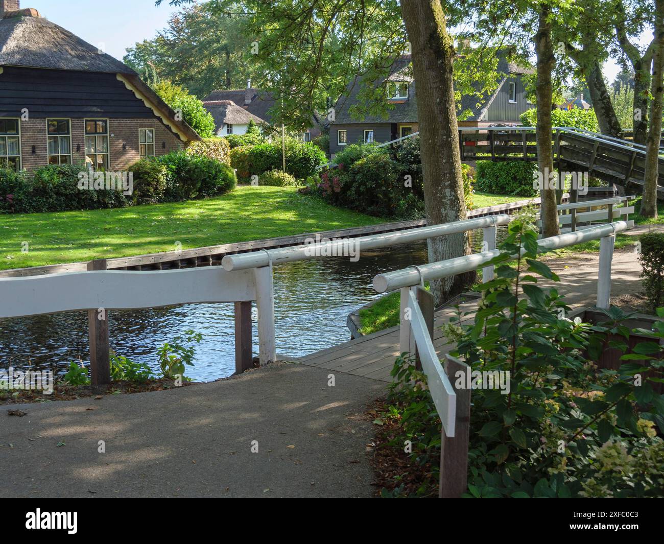 Eine friedliche Szene mit einer Brücke, einem Kanal und Häusern umgeben von Natur, giethoorn, niederlande Stockfoto