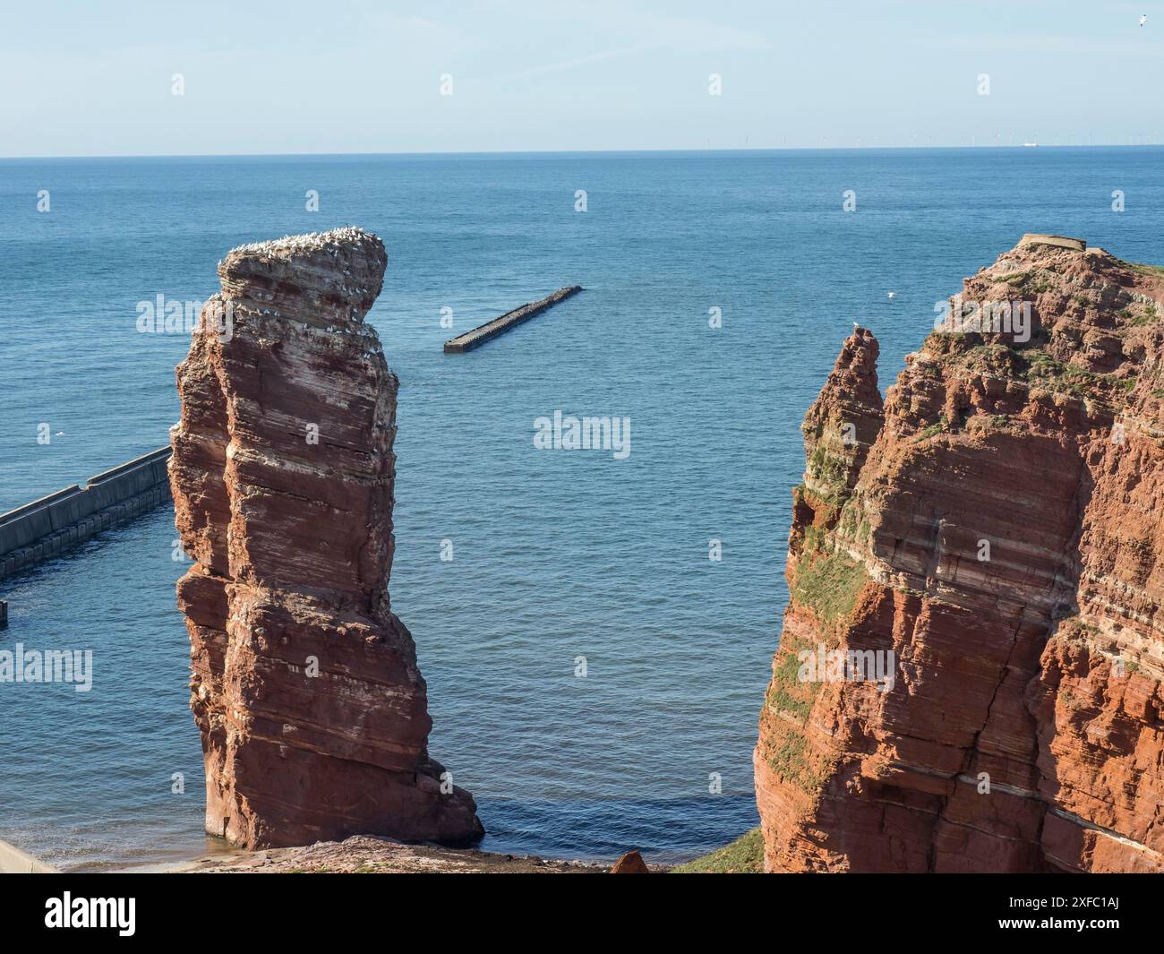 Hohe Felsen erheben sich aus dem Meer, umgeben von blauem Himmel und ruhigem Wasser, helgoland, Nordsee, deutschland Stockfoto