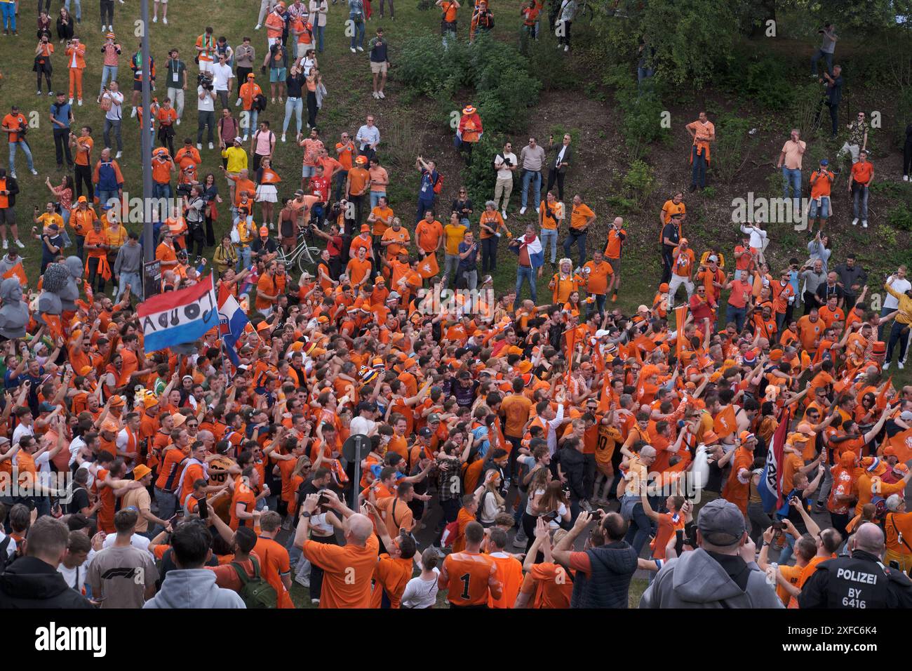 Holländischer Oranje Umzug durch den Olympiapark Holländischer Oranje-Umzug durch den Olympiapark. Fans in Orange laufen singend und feiert hinter dem BU Stockfoto