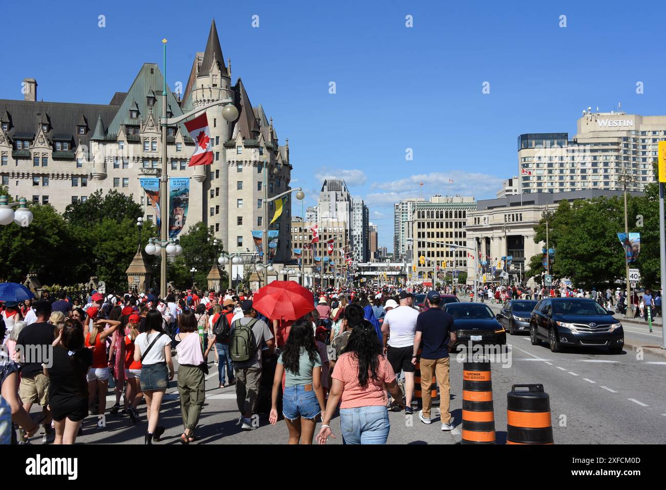 Ottawa, Kanada - 1. Juli 2024: Eine große Gruppe von Menschen geht in Richtung Rideau Street auf einem Teil der Wellington Street, der während des Canada Day, einem jährlichen gesetzlichen Feiertag, der den Jahrestag der kanadischen Konföderation am 1. Juli 1867 feiert, für Fußgänger gesperrt ist Stockfoto