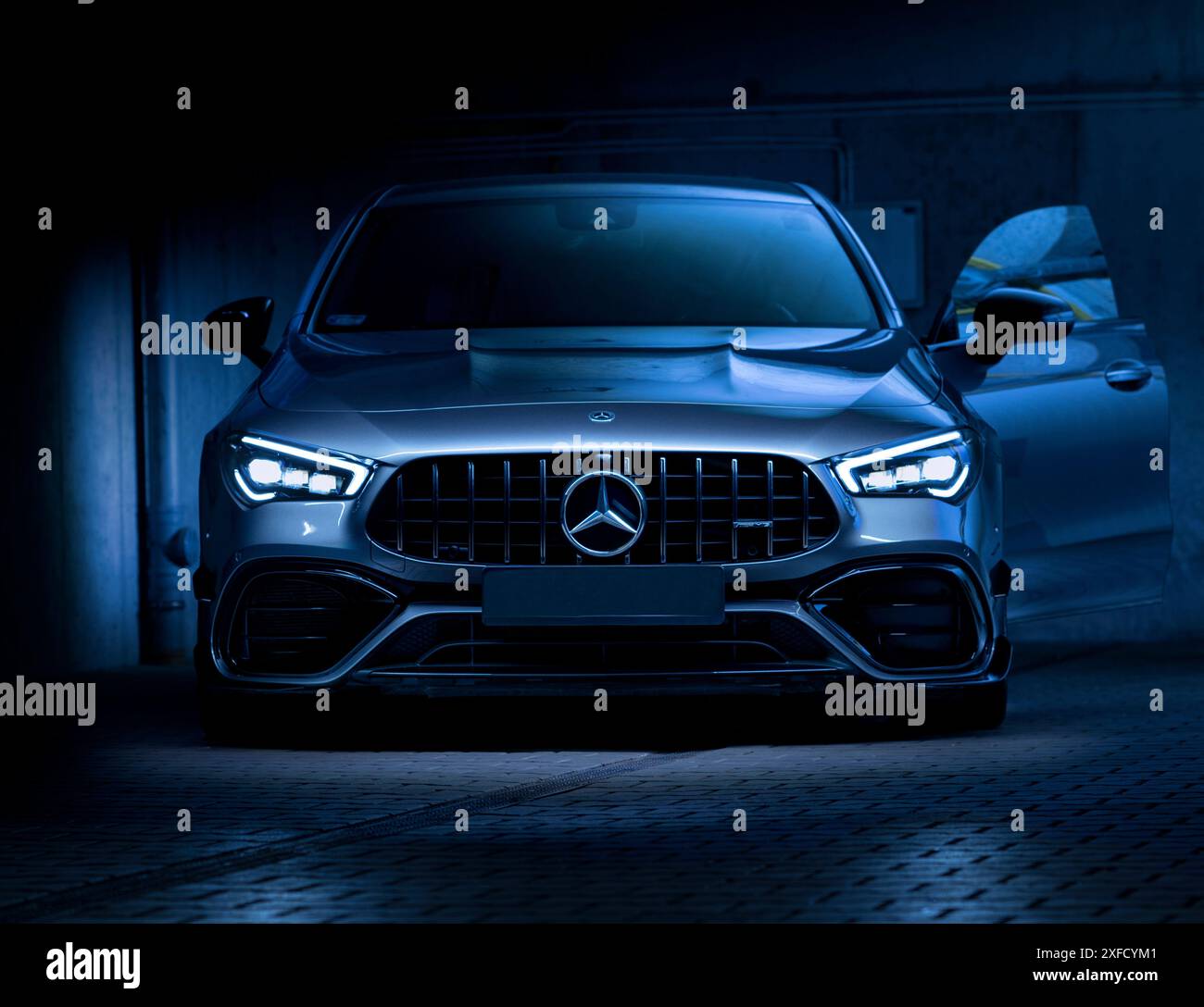 Mercedes CLA 45s AMG, 241 km, Baujahr: 2020. Vorderseite eines Sportwagens mit LED-Lampen, bei kühlem Licht. Aus dem Schwarz. Steht mit geöffneter Tür Stockfoto