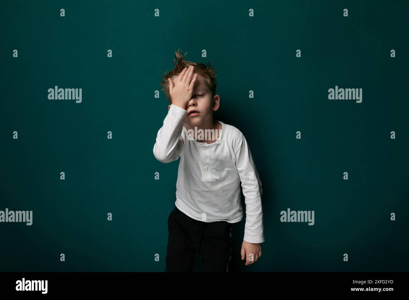 Junge, Der Das Gesicht Mit Den Händen Bedeckt Stockfoto