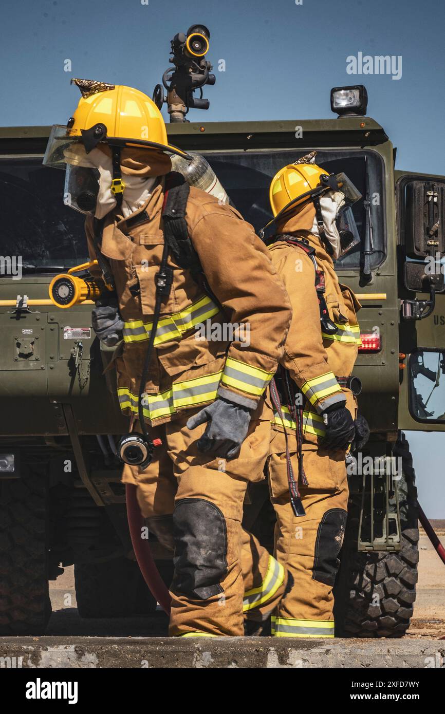 U.S. Marines with Marine Wing Support Squadron 471, Marine Aircraft Group 41, 4th Marine Aircraft Wing, bereiten Schläuche vor, um auf einen simulierten Flugzeugbrand während einer Base Recovery nach dem Angriff zu reagieren, als Teil der integrierten Trainingsübung 4-24 im Camp Wilson, Marine Corps Air-Ground Combat Center, Twentynine Palms, Kalifornien, 22. Juni 2024. Ziel dieser Simulation ist es, die Einsatzbereitschaft zu erhalten, indem die Fähigkeit demonstriert wird, einen Flugplatz nach einem simulierten Angriff schnell wieder einsatzbereit zu machen. ITX ermöglicht es der Marine Forces Reserve, geografisch verteilte Kräfte zu mobilisieren Stockfoto