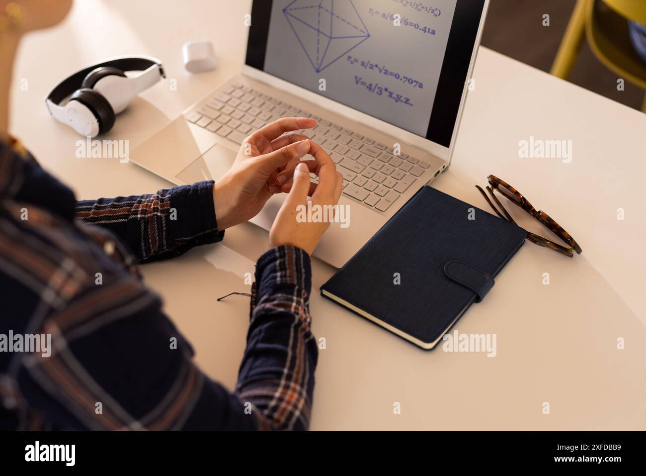 Geometrie studieren, Teenager mit Notebook und Kopfhörern auf dem Schreibtisch Stockfoto