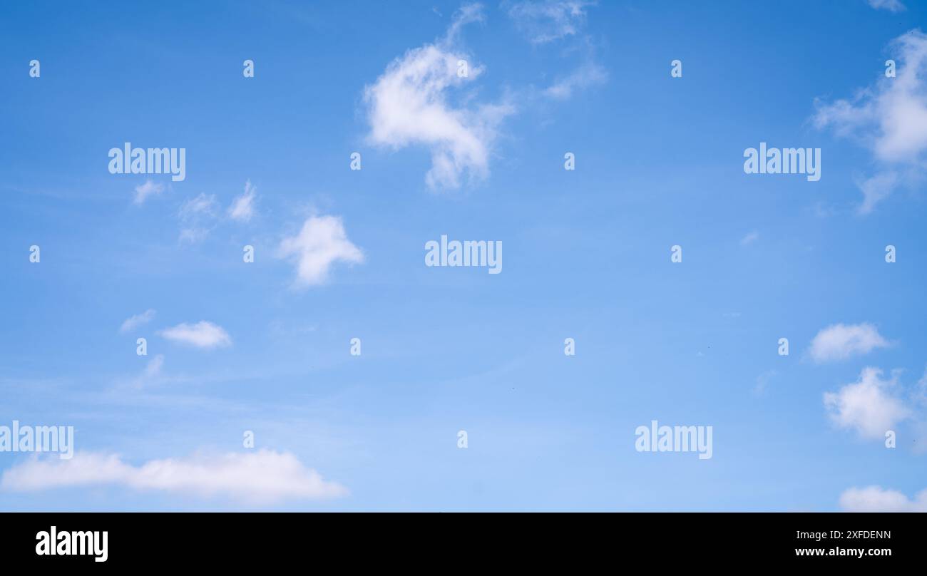 Schöner blauer Himmel und weiße Kumuluswolken abstrakter Hintergrund. Wolkenuntergrund. Blauer Himmel und flauschige weiße Wolken an sonnigen Tagen. Wunderschönes Blau Stockfoto