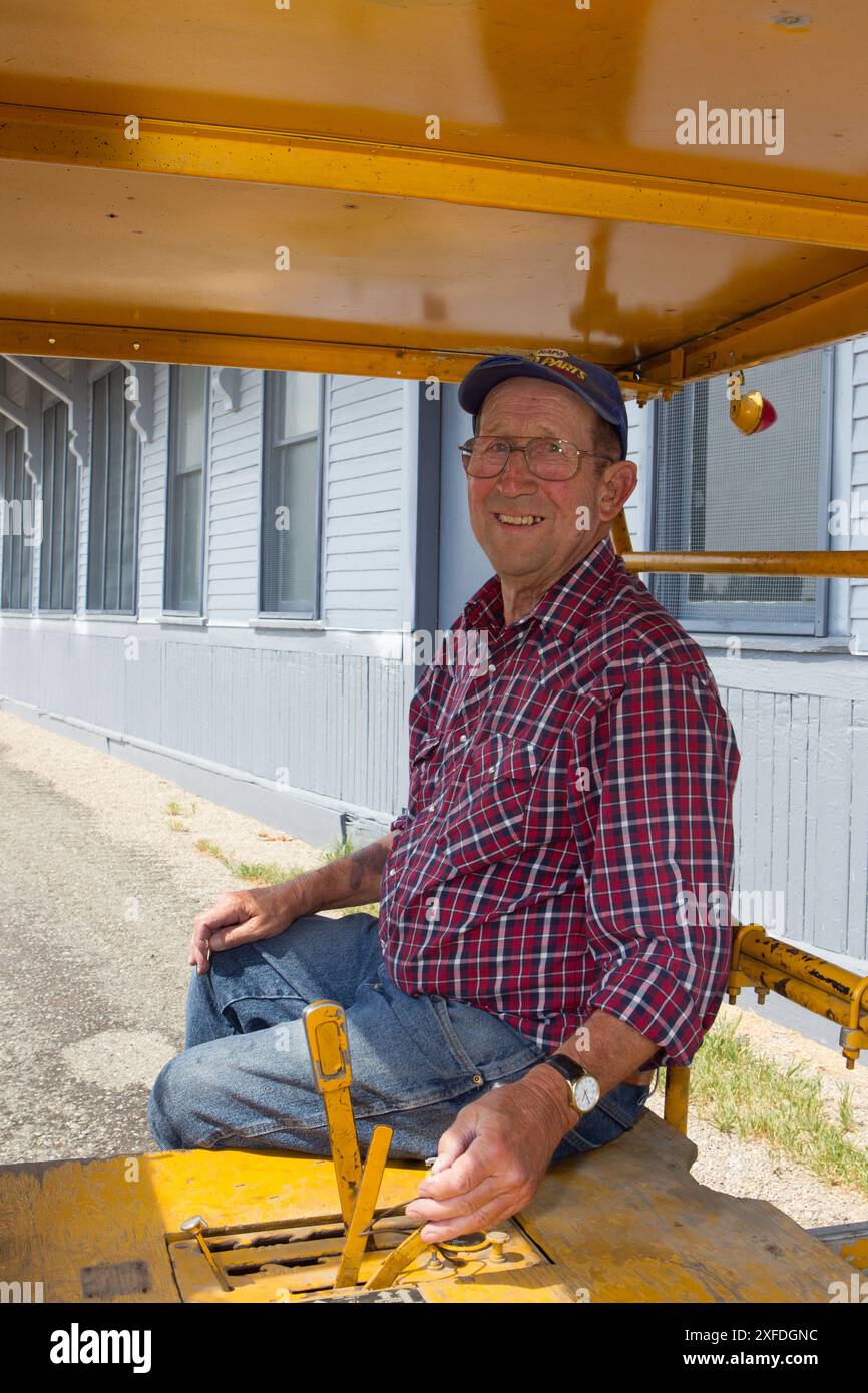 Der ehemalige Mitarbeiter der Milwaukee Road sitzt im „Speeder“, wie er es bei der Reparatur der Schienen verwendet hat, im Milwaukee Depot Museum, Harlowton, MT. HERR) Stockfoto