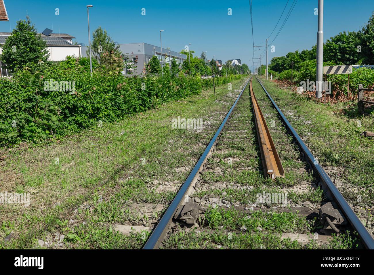 Neue Bahngleise oder Stahlgleisen, die auf dem Boden neben einem alten vernachlässigten Gleis liegen und auf Modernisierung oder Renovierung warten. Bahnstrecke Stockfoto