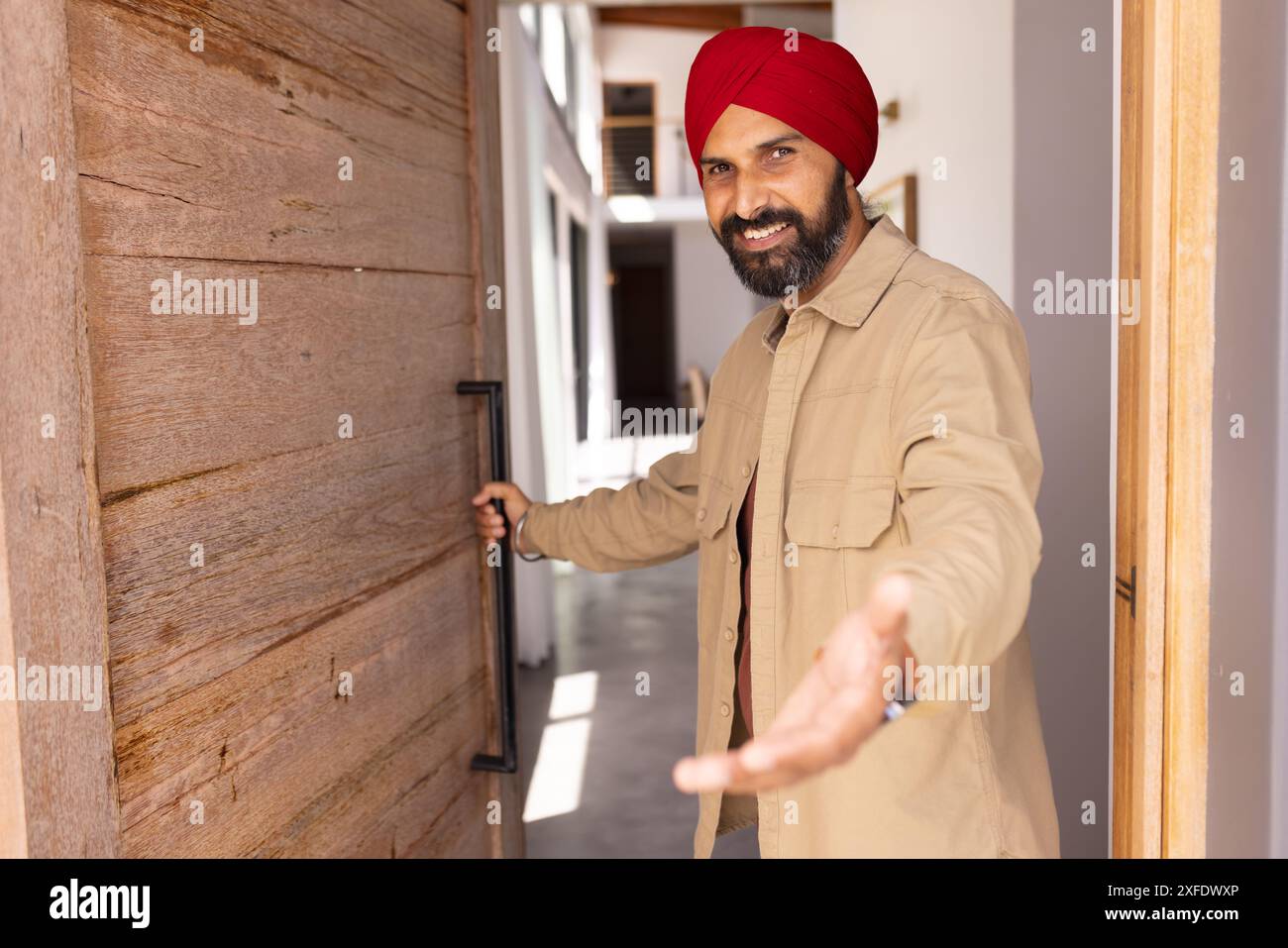 Begrüßungsgast, Mann im Turban, der Tür öffnet und Gesten im Haus macht, Kopierraum Stockfoto