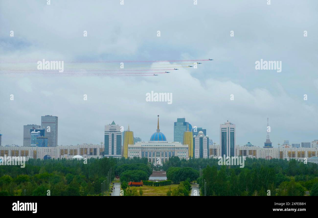 (240703) -- ASTANA, 3. Juli 2024 (Xinhua) -- kasachische Kampfflugzeuge bemalen den Himmel mit farbigen Rauchspuren, während der kasachische Präsident Kassym-Jomart Tokayev am 3. Juli 2024 eine Begrüßungszeremonie für den Besuch des chinesischen Präsidenten Xi Jinping in Astana, Kasachstan, veranstaltet. Eine Gruppe von sechs Jets, die über den Präsidentenpalast flogen, hinterließ farbige Rauchspuren in Rot und Gelb, Farben der chinesischen Nationalflagge. XI ist auf einem Staatsbesuch in Kasachstan und wird hier an der 24. Sitzung des Rates der Staatschefs der Shanghai Cooperation Organization (SCO) teilnehmen. (Xinhua/Wang Jianhua) Stockfoto