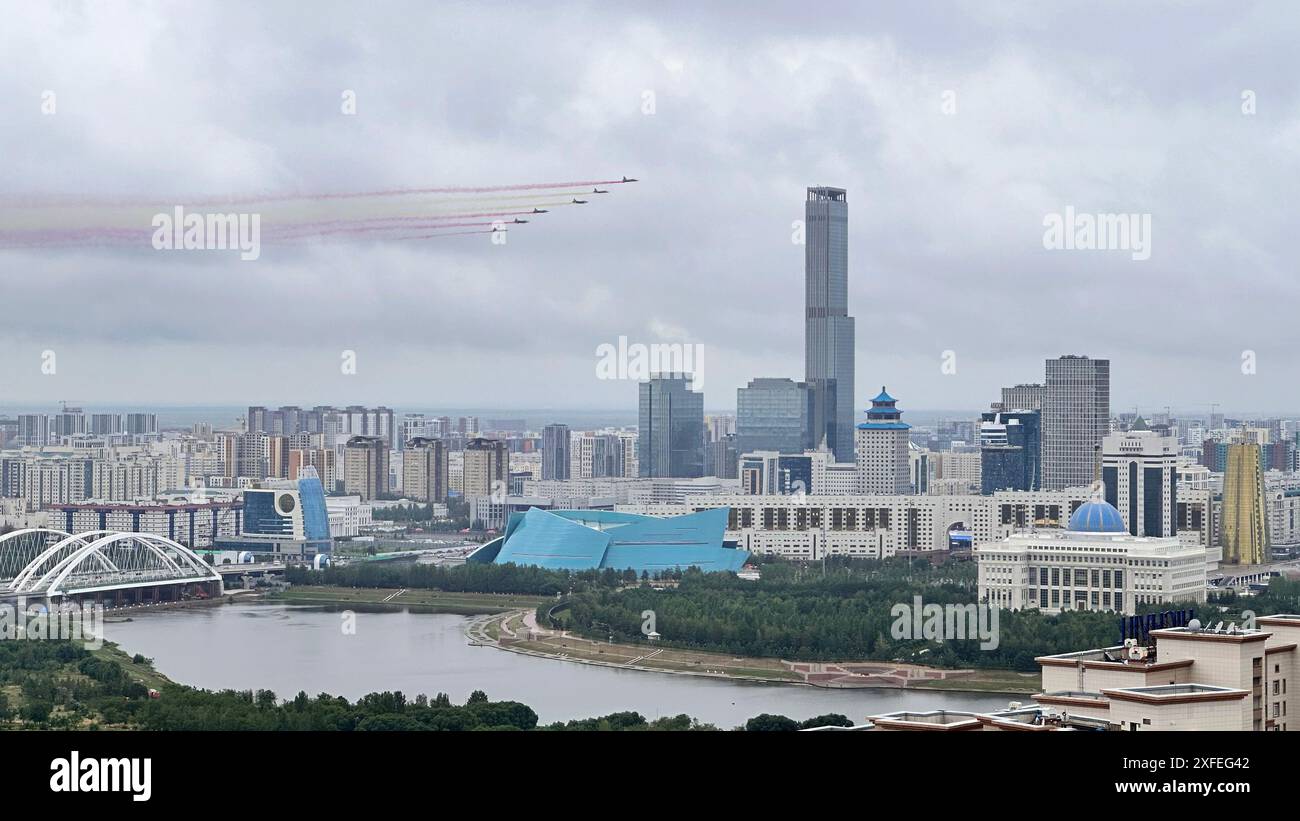 Astana, Kasachstan. Juli 2024. Kasachische Kampfflugzeuge bemalen den Himmel mit farbigen Rauchspuren, während der kasachische Präsident Kassym-Jomart Tokayev am 3. Juli 2024 eine Begrüßungszeremonie für den Besuch des chinesischen Präsidenten Xi Jinping in Astana, Kasachstan, veranstaltet. Eine Gruppe von sechs Jets, die über den Präsidentenpalast flogen, hinterließ farbige Rauchspuren in Rot und Gelb, Farben der chinesischen Nationalflagge. XI ist auf einem Staatsbesuch in Kasachstan und wird hier an der 24. Sitzung des Rates der Staatschefs der Shanghai Cooperation Organization (SCO) teilnehmen. Quelle: Lu Jinbo/Xinhua/Alamy Live News Stockfoto