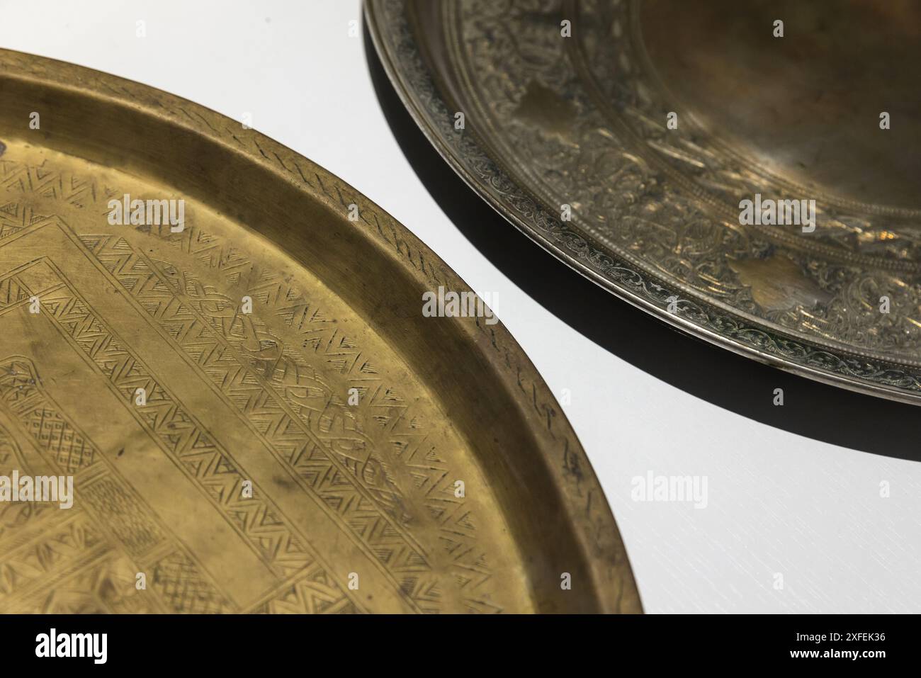 Alte Kupferschalen mit geprägten arabischen Mustern stehen auf einem weißen Tisch, Nahaufnahme mit selektivem Weichfokus Stockfoto Alte Kupferschalen mit geprägten arabischen Mustern stehen auf einem weißen Tisch, Nahaufnahme mit selektivem Weichfokus Stockfoto