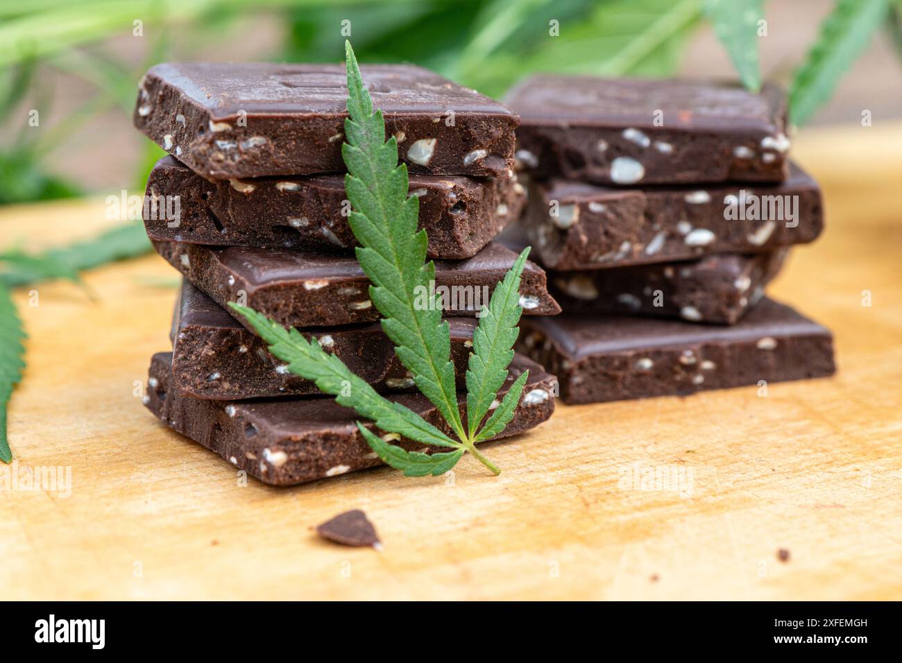 Marihuana Blatt essbares Cannabis mit CBD und Getreide knusprige Lebensmittel Mehrkornschokolade, Thai Hanf und Öl extrahierte Canabis auf braunem hölzernem Hintergrund. Stockfoto