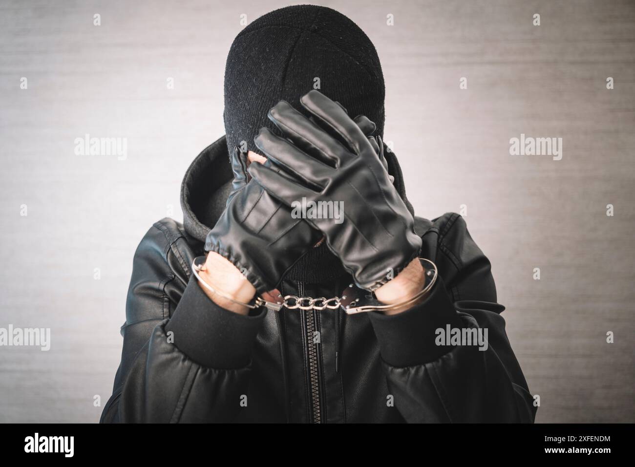 Festgenommener Mann mit Handschellen. Ein Verbrecher in Handschellen bedauert das Verbrechen. Stockfoto