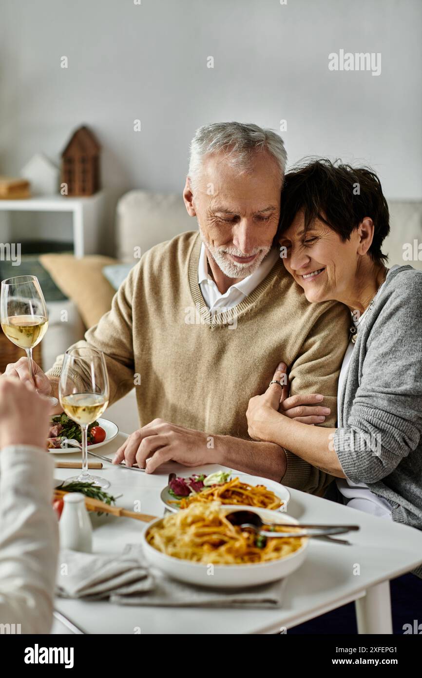 Erwachsene Eltern essen mit ihrem Sohn und seinem Partner bei einem gemütlichen Abendessen zu Hause. Stockfoto