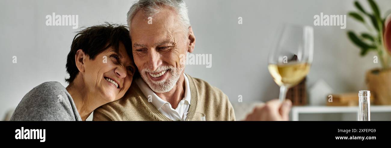 Fröhliche Eltern essen mit ihrem Sohn und seinem Partner bei einem gemütlichen Abendessen zu Hause. Stockfoto