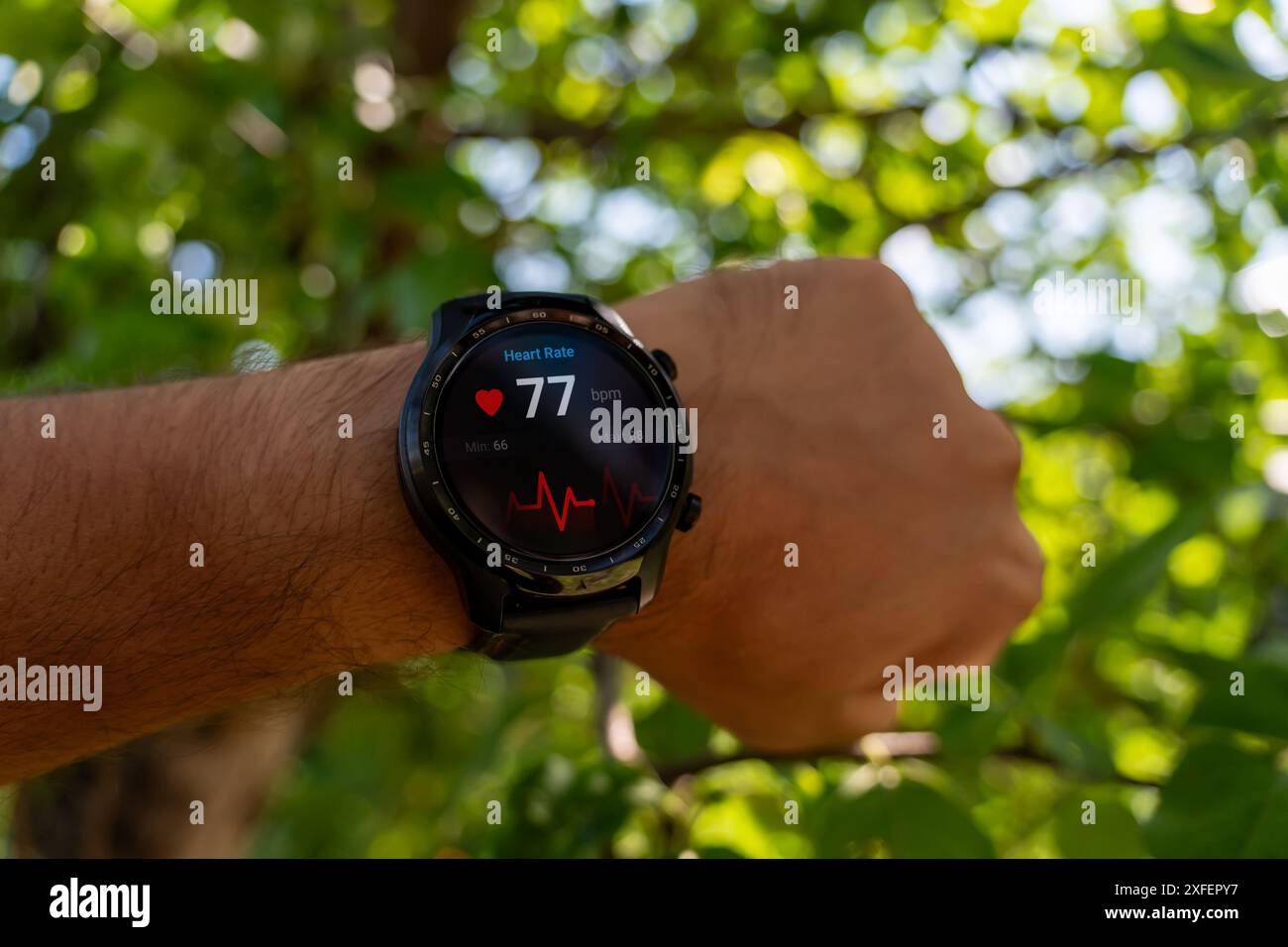 Nahaufnahme des Smart Watch Health Tracker mit der auf dem Bildschirm angezeigten Herzfrequenz. Modernes, elegantes und innovatives tragbares Gerät. Sportler überprüft sein Hörvermögen Stockfoto