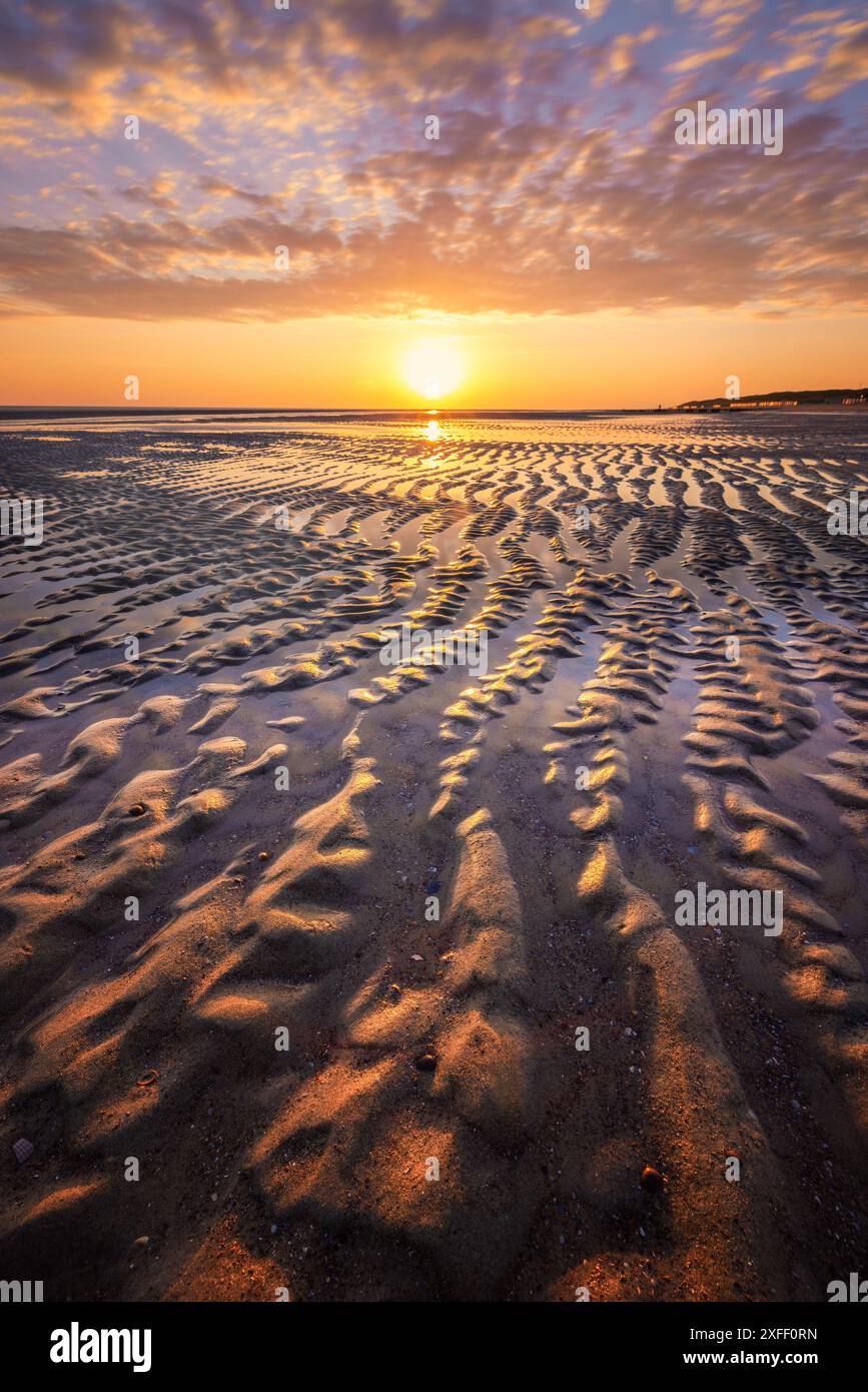 Ein wunderschönes Meeresbild am Strand in der Nähe von Burgh-Haamstede mit spektakulären lebhaften Farben und starken Linien im Sand mit Reflexen. Stockfoto