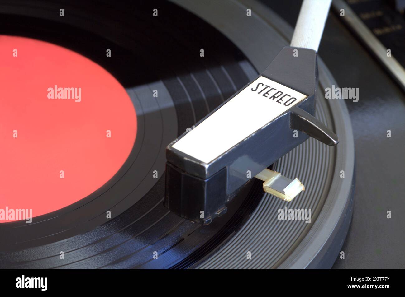 Alter Vintage-Stereo-Plattenspieler mit 7-Zoll-Schallplatte mit rotem Etikett auf der Matte Draufsicht in Nahaufnahme Stockfoto