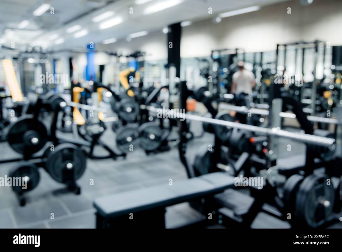 Verschwommenes Bild der Inneneinrichtung des Fitnessstudios und der Fitnessgeräte. Modernes Hintergrundkonzept. Stockfoto