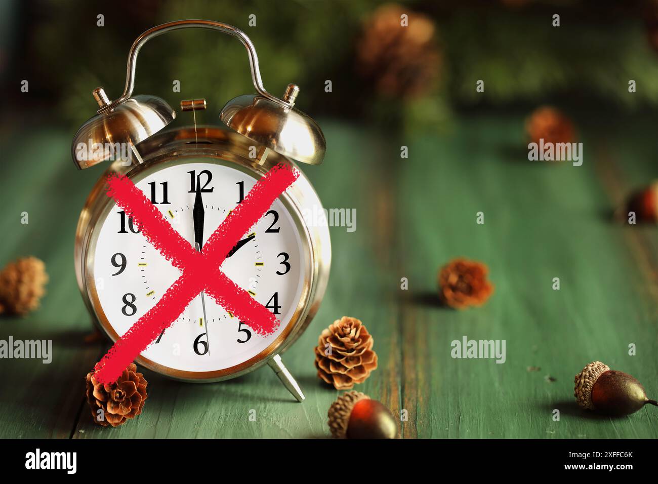 Sagen Sie Nein zur Sommerzeit mit diesem Konzept eines roten x über einem grünen Holztisch. Selektiver Fokus mit unscharfem Hintergrund. Stockfoto