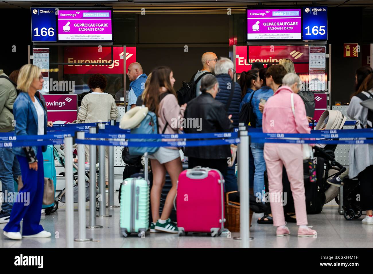 Düsseldorf, Deutschland. Juli 2024. Passagiere stehen am Flughafen vor den Gepäckabgabe- und Check-in-Schaltern von Eurowings an. Quelle: Christoph Reichwein/dpa/Alamy Live News Stockfoto