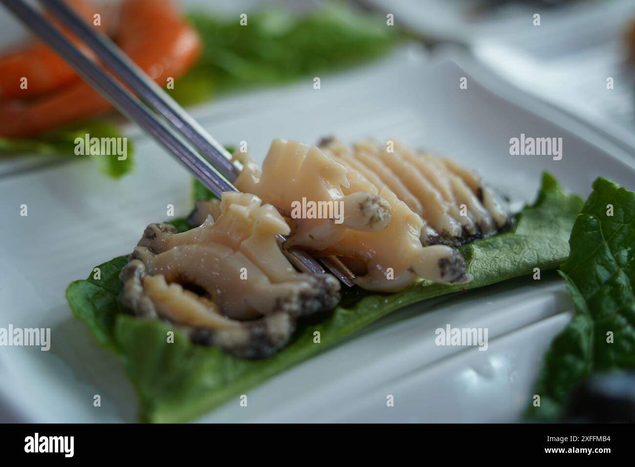 Es wird frisches rohes Abalone Sashimi serviert Stockfoto