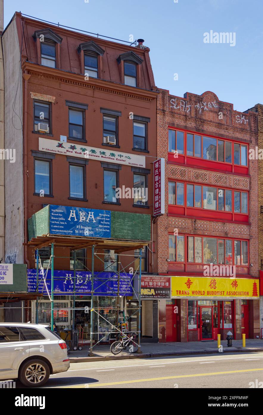 NYC Chinatown: 9 und 7 East Broadway, flache Backsteinhäuser. Nummer 9 (hinter dem Gerüst) beherbergt Büros und Geschäfte; Nummer 7 ist ein buddhistischer Tempel. Stockfoto