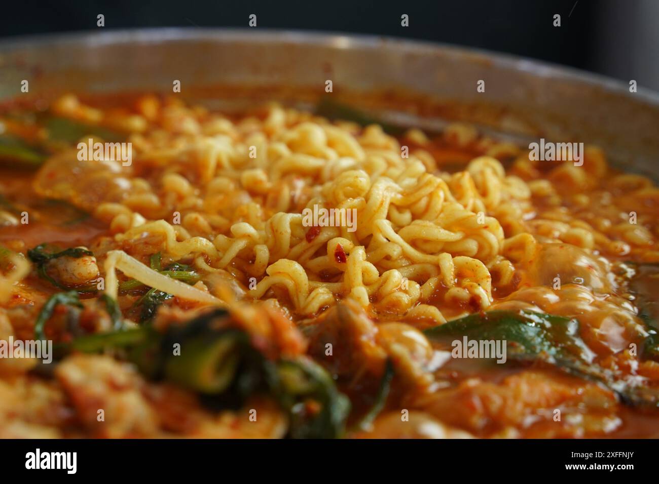 Koreanische Esskultur: Ramen mit Fischeintopf, gewürzt mit rotem Pfefferpulver Stockfoto