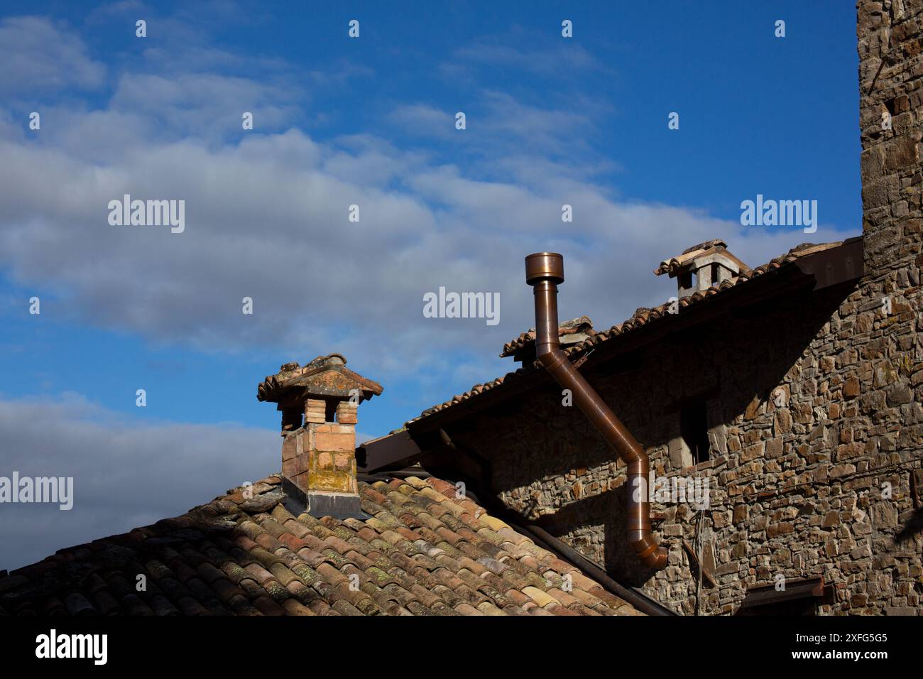 Altes Steinhausdach mit neuen Kupferkaminrohren. Stockfoto