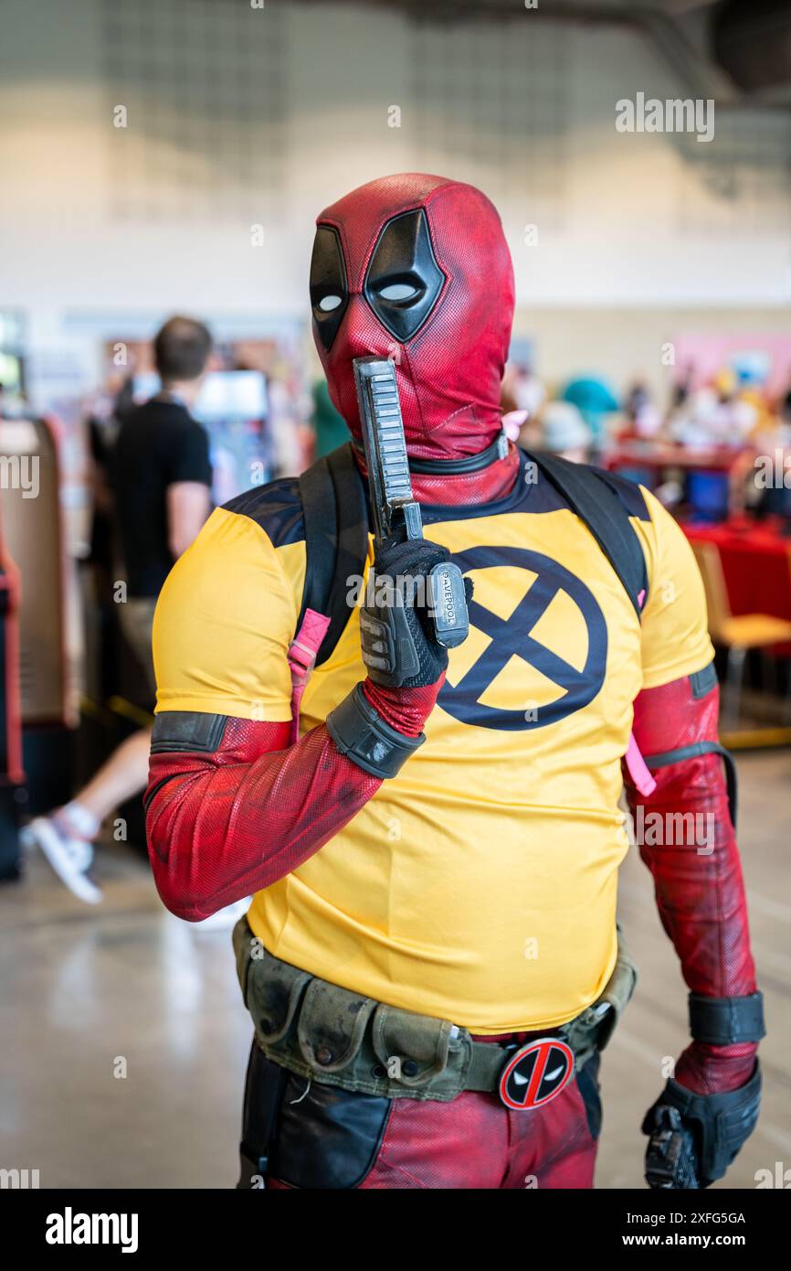 HARROGATE, GROSSBRITANNIEN, 22. JUNI 2024. Porträt eines männlichen Cosplayer, der als Deadpool gekleidet ist und mit einer Waffe und Wolverine-Kleidung posiert Stockfoto
