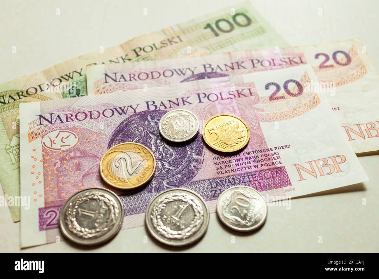 Nahaufnahme polnischer Banknoten und Münzen, die auf der weißen Theke liegen Stockfoto