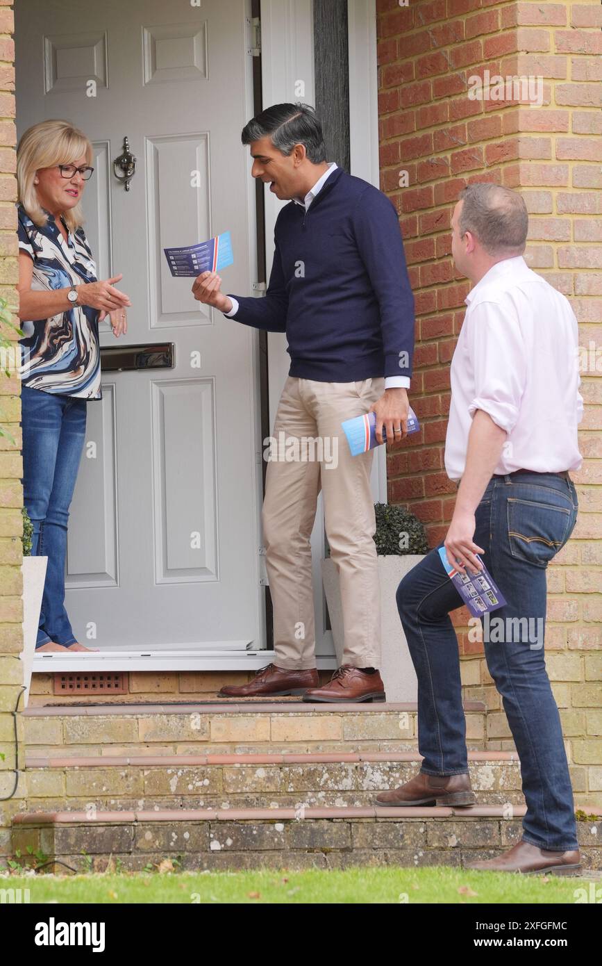 Premierminister Rishi Sunak mit dem lokalen Parlamentskandidaten Paul Holmes (rechts) klopfte an die Türen des First Drive, während er sich auf dem Wahlkampfpfad der allgemeinen Wahl befand. Auf dem First Drive, während auf dem Wahlkampfpfad der Wahl. Bilddatum: Mittwoch, 3. Juli 2024. Stockfoto