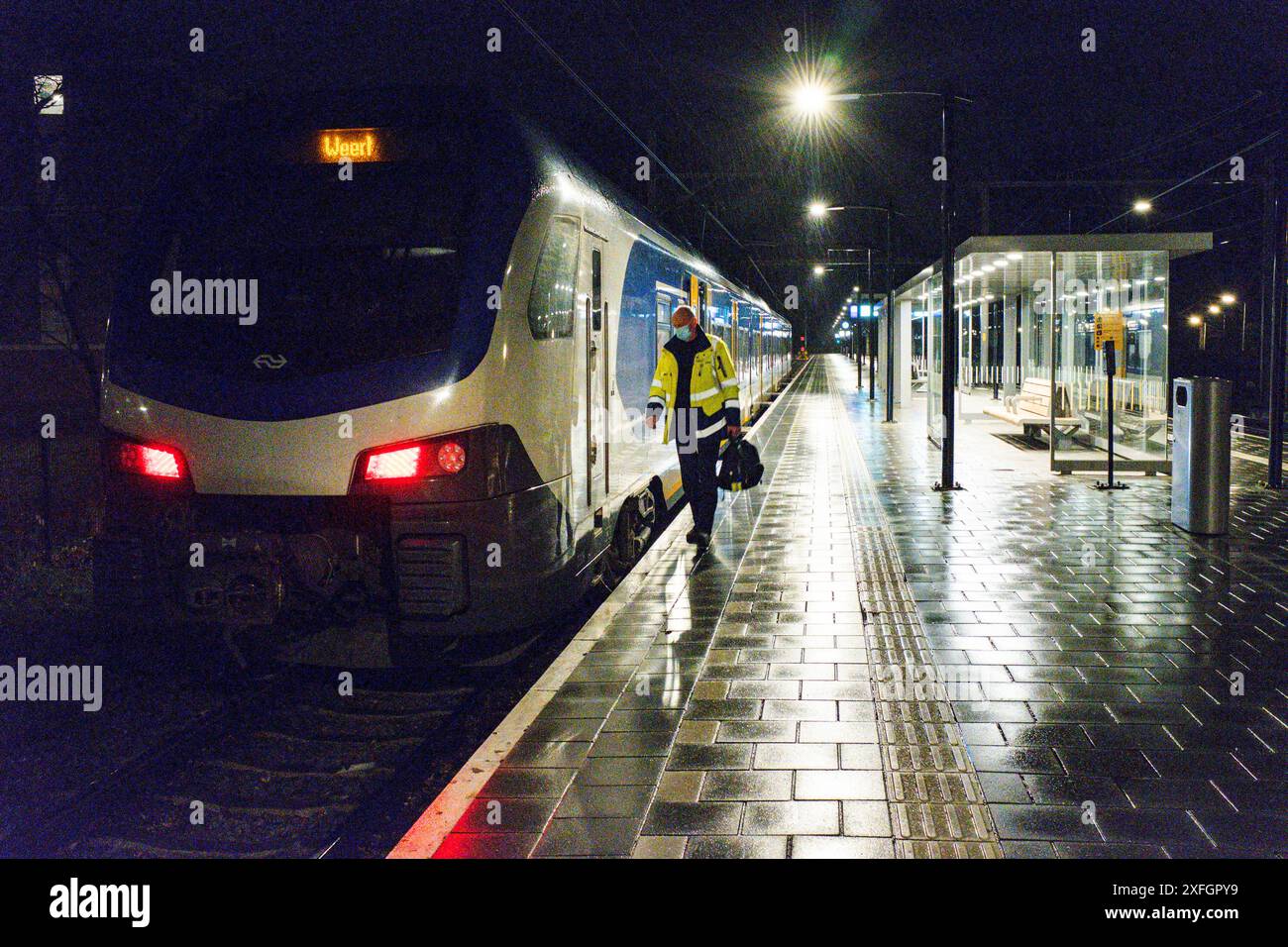 Verlassener Bahnhof Lonely Train Driver geht in Richtung seiner Kabine für eine weitere, einsame Fahrt in Richtung Weert Railway Station während einer verlassenen Sperrstunde Nacht, um die Corona/COVID-19 Krise zu bekämpfen. Tilburg, Niederlande. Tilburg Tilburg Universiteit Noord-Brabant Nederland Copyright: XGuidoxKoppesxPhotox Stockfoto