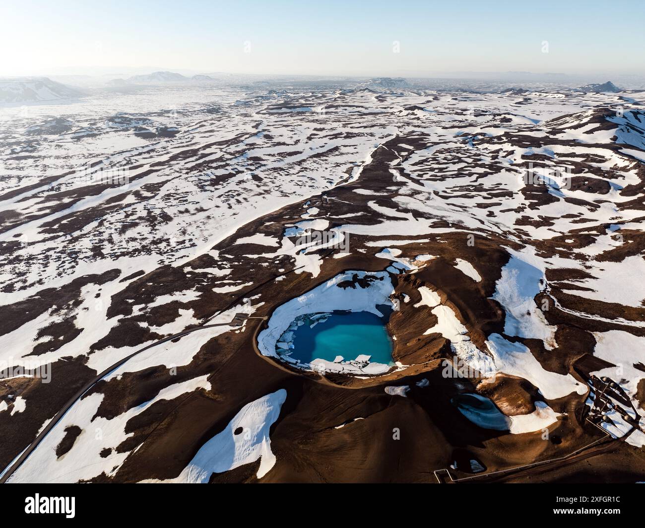 Blick von oben, atemberaubender Blick auf den Krafla Viti Krater aus der Luft. Dieser wunderschöne Krater ist mit blauem Wasser gefüllt und von einem geothermischen Gebiet umgeben. Stockfoto