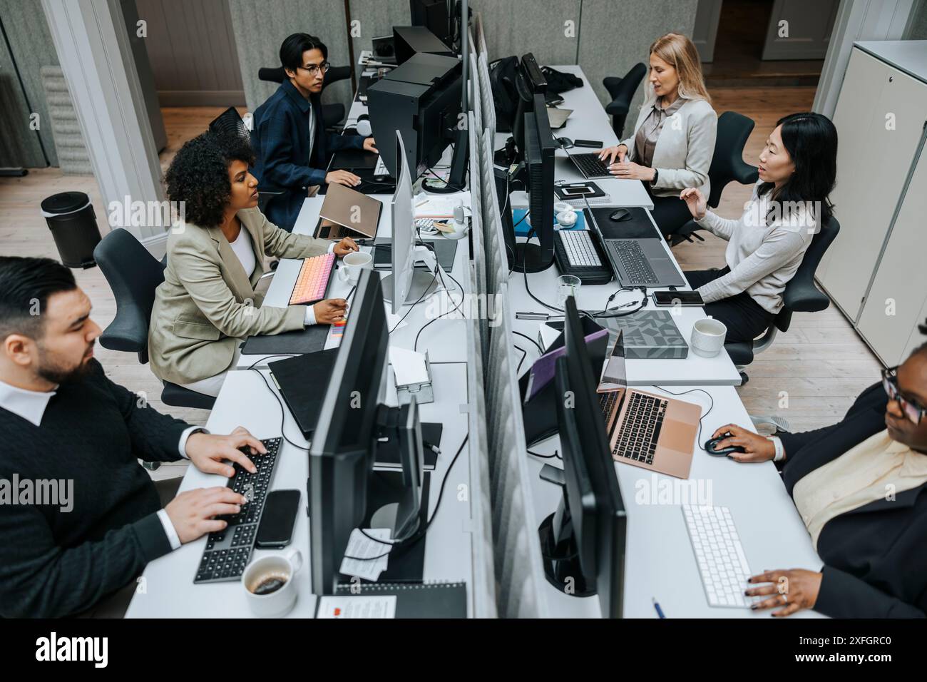 Hochwinkelansicht einer multirassischen Gruppe männlicher und weiblicher Geschäftsleute, die im Büro arbeiten Stockfoto