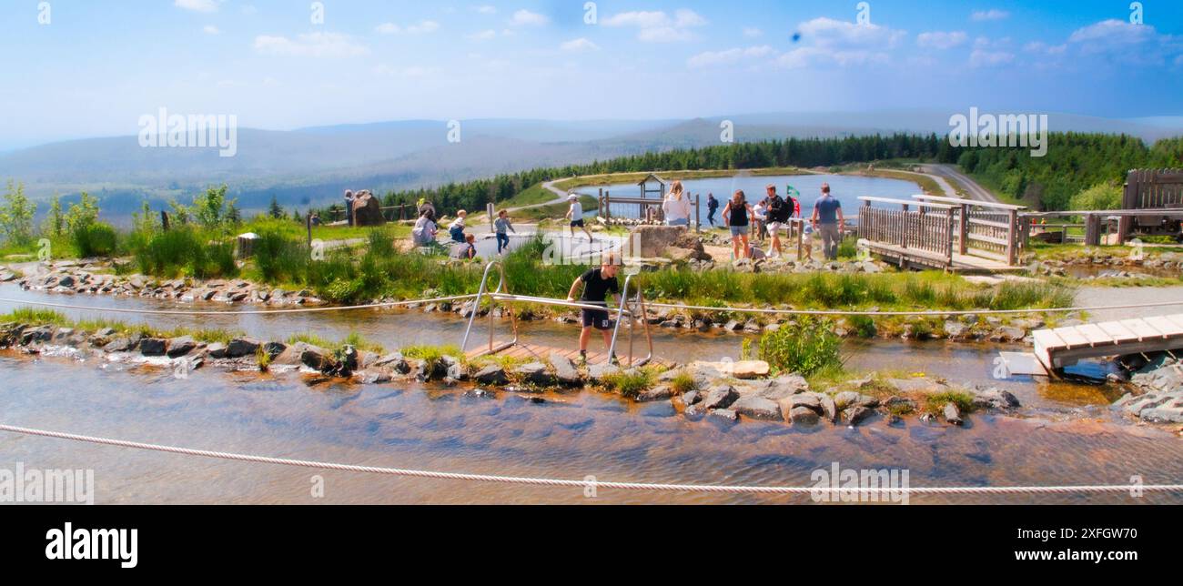 Ein Junge rutscht auf einer Holzbar auf einem Wasser auf dem Spielplatz auf dem Wurmberg, Nationalpark Harz, Deutschland, Familienausflug, Outdoor-Aktivitäten für Kinder Stockfoto