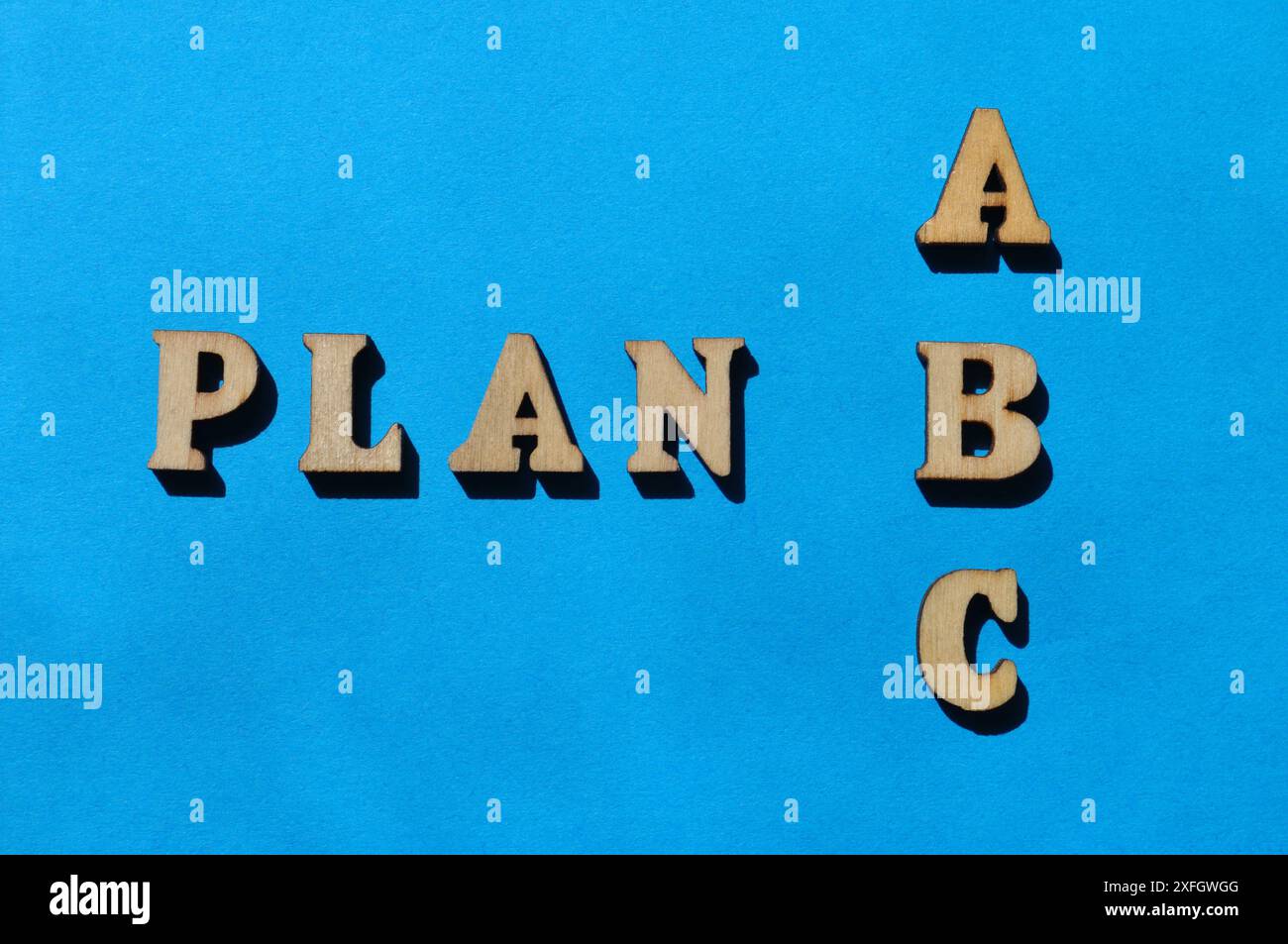 Plan A, B, C, Wörter in hölzernen Buchstaben isoliert auf blauem Hintergrund als Banner-Überschrift Stockfoto