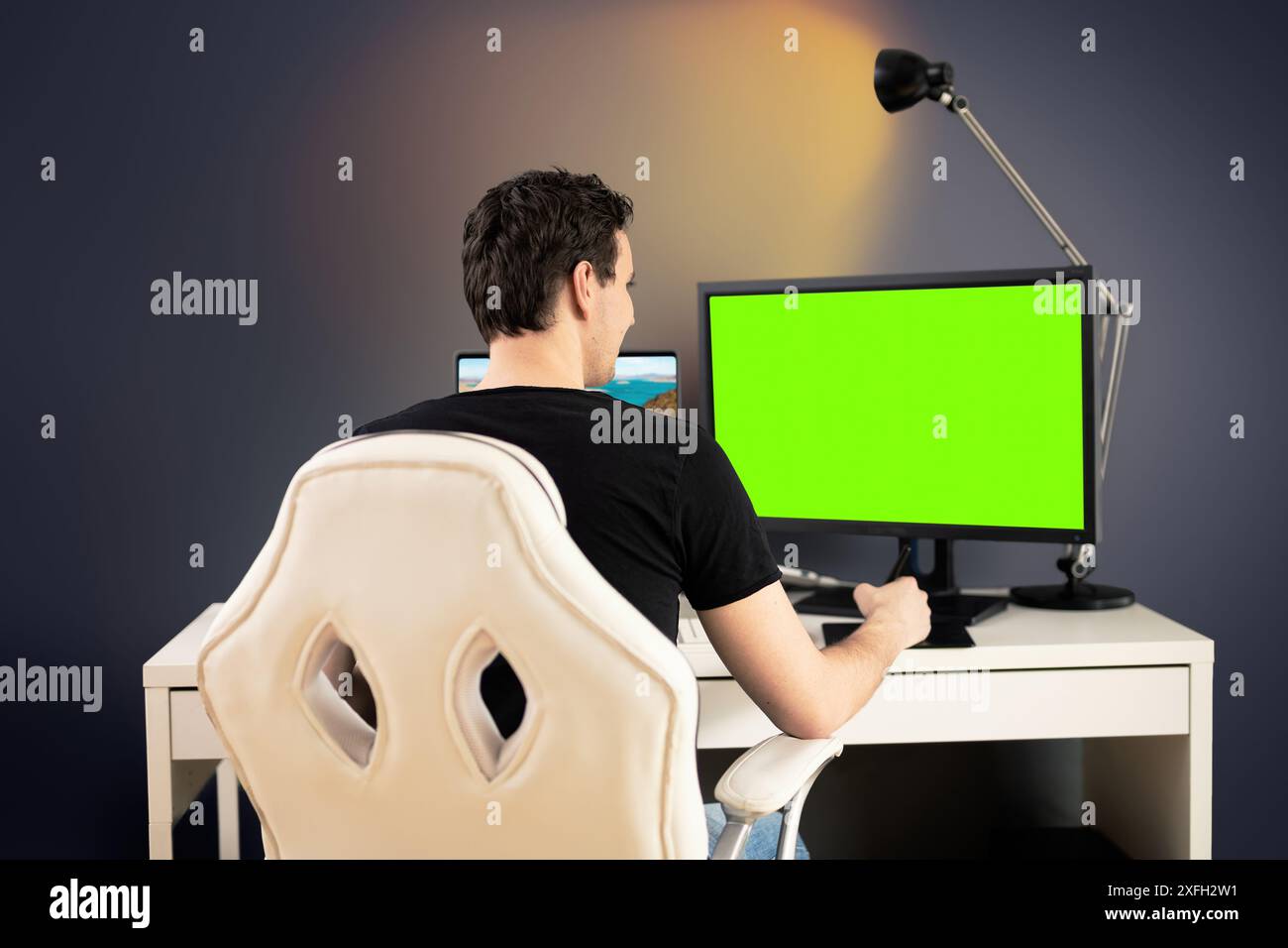 Freiberuflicher Video-Editor sitzen auf weißem Stuhl und Schreibtisch in seinem Büro und schneiden einige Videomaterial mit Grafik-Tablet Stockfoto