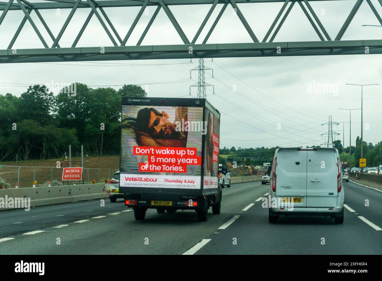 3. Juli 2024. Am letzten Tag vor der Wahl der britischen Parlamentswahlen wird ein Werbewagen der Labour Party auf der M25 in Essex mit der Botschaft „Wecken Sie nicht mehr bis zu fünf Jahre der Tories“ und einem Bild von Rishi Sunak im Bett gesehen. Stockfoto