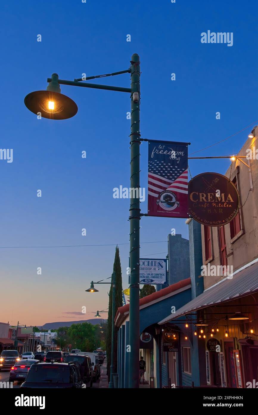 Patriotisches Stadtbanner an der Straßenlaterne entlang der Main Street in der Abenddämmerung in der Innenstadt von Cottonwood, Arizona – April 2024 Stockfoto