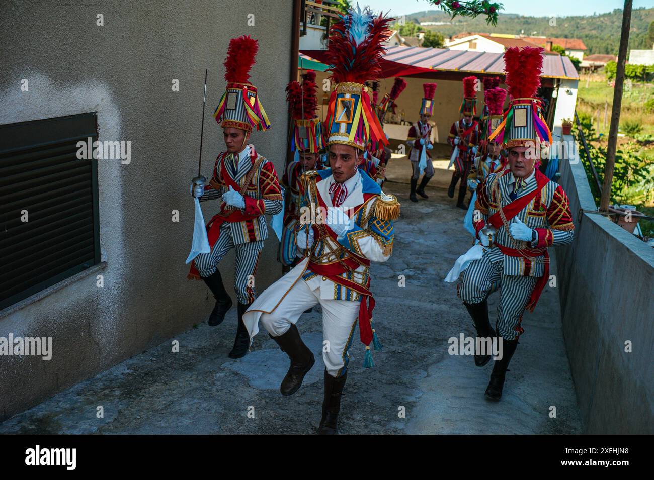 Das Festival „Bugiada e Mouriscada“ in São João de Sobrado, Valongo, Portugal, erwacht am 24. Juni zum Leben. Die Mourisqueiros tragen bunte Kostüme und führen historische Schlachten gegen die Bugios in einer lebhaften Feier der Tradition und Geschichte nach. Stockfoto